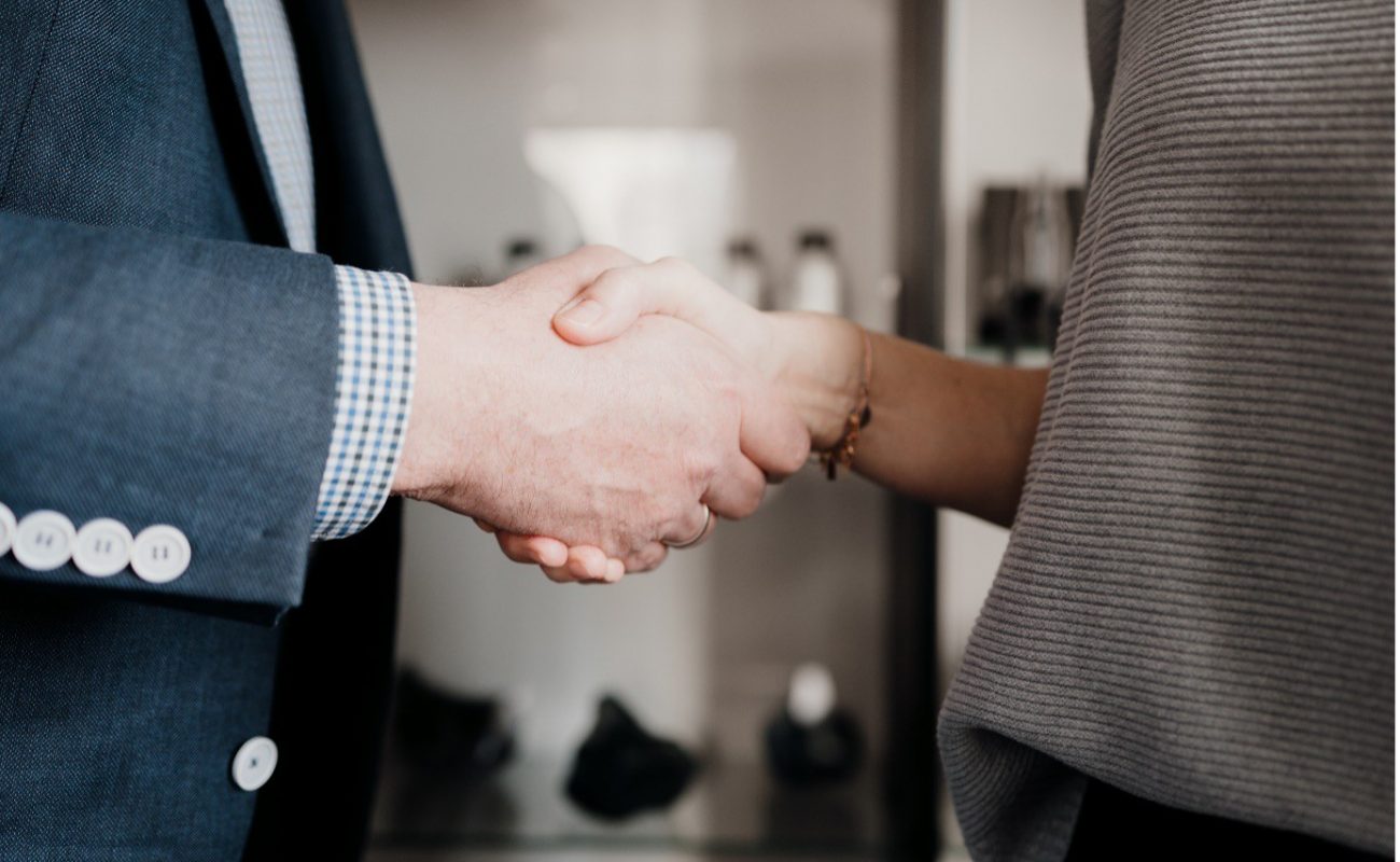 zwei Personen gebe sich zur Vereinbarung die Hände